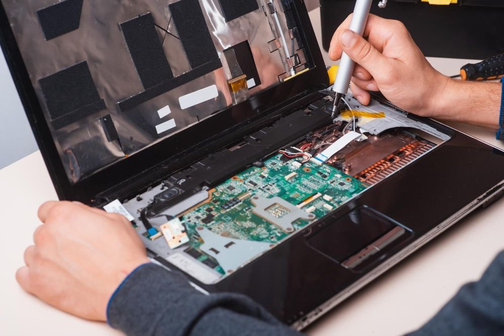 Technician repairing an opened laptop