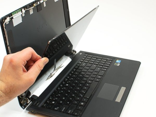Technician replacing a laptop LCD screen panel