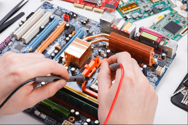 Technician testing a computer motherboard with a multimeter
